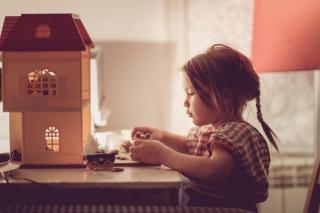 Little girl with a dollhouse.