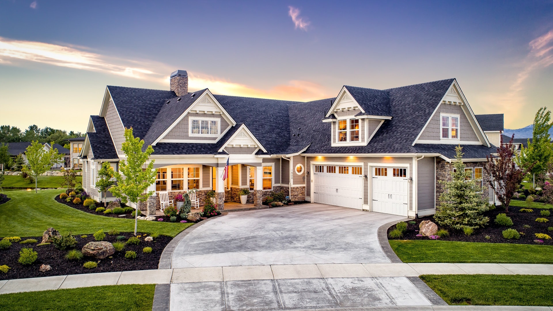 Spacious suburban home with three-car garage, landscaped yard, and welcoming front porch at sunset in boise idaho.