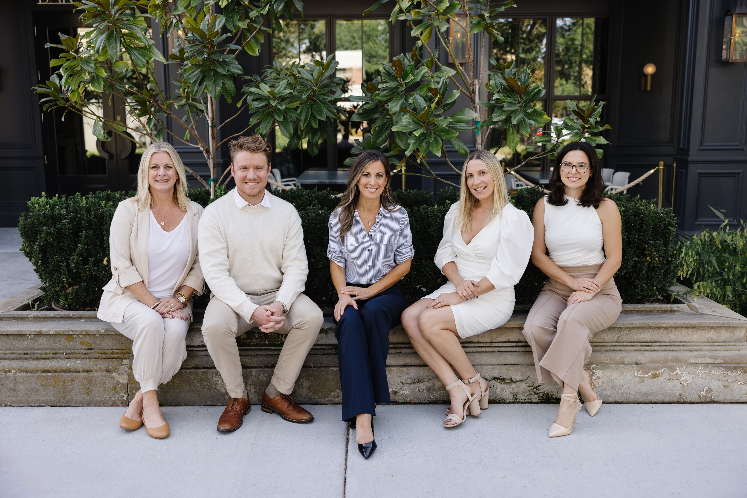 McFerrin Real Estate team sit on a ledge